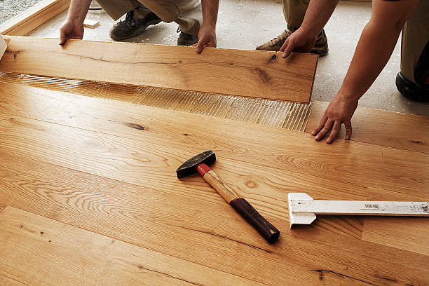 Ouvriers en train de poser des lames de parquet collé