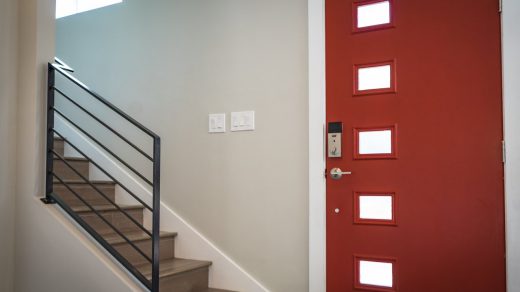 escalier à côté d'une porte d'entrée rouge